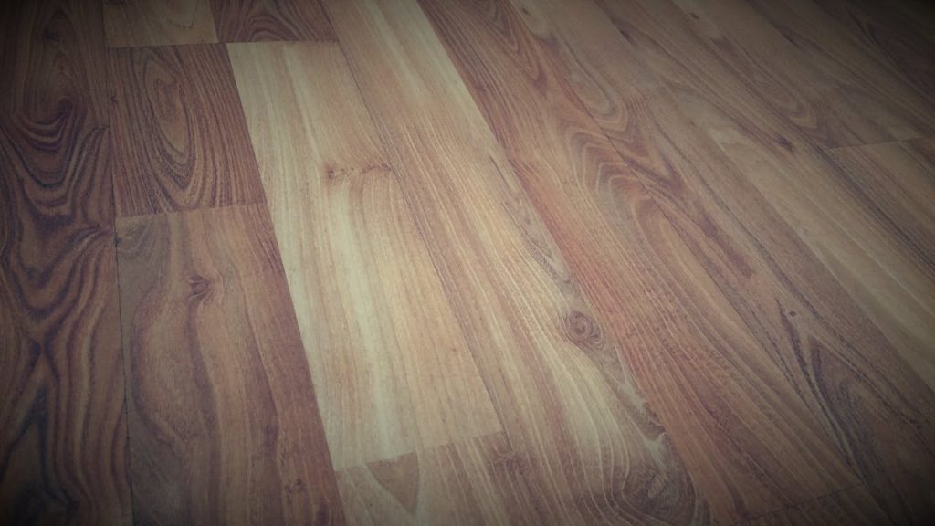 Close-up of a wooden floor showcasing a rich brown grain pattern with a rustic texture.