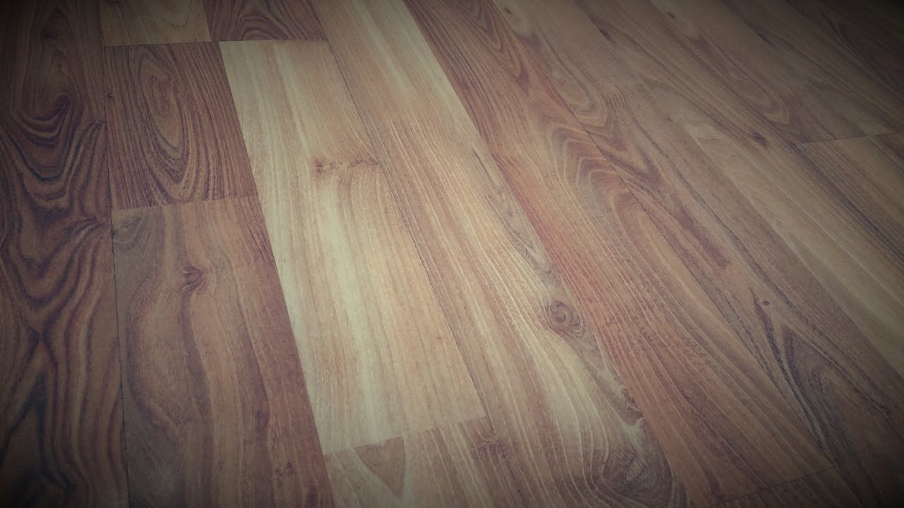 Close-up of a wooden floor showcasing a rich brown grain pattern with a rustic texture.